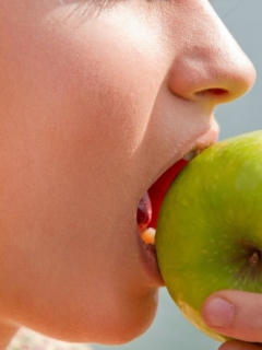 Mujer muerde manzana.