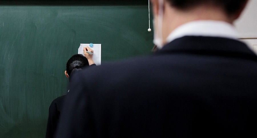 Profesor y alumna en salón de clase