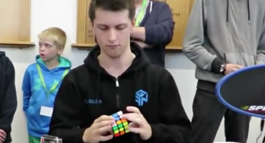 Joven resuelve cubo de Rubik.