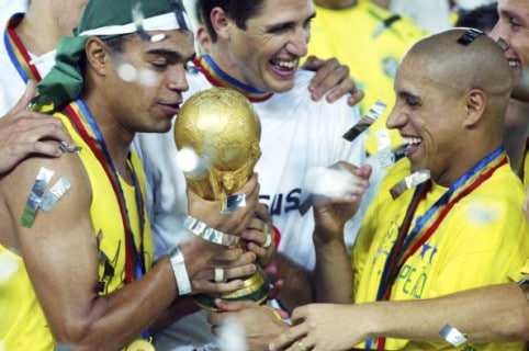 Denilson y Roberto Carlos con el trofeo del Mundial
