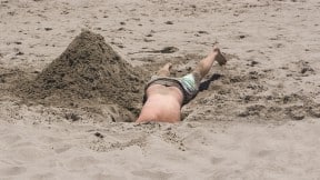Hombre en hueco en una playa