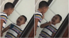 Niño se mira al espejo.