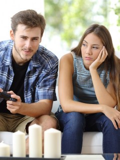 Hombre jugando viodeojuegos y novia enojada