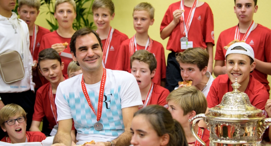Roger Federer con recogebolas