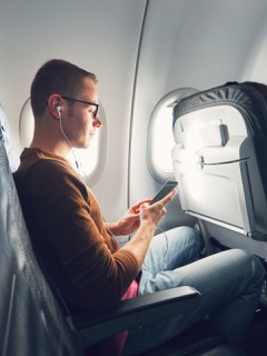 Hombre con celular en avión