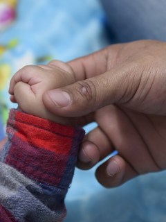Hombre toma mano de bebé