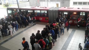 Usuarios de Transmilenio intentando ingresar a un bus articulado.