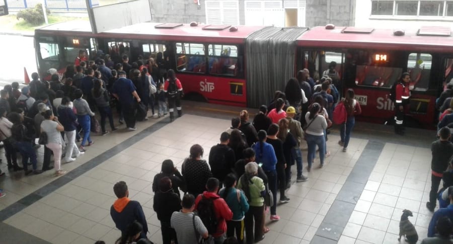 Usuarios de Transmilenio intentando ingresar a un bus articulado.