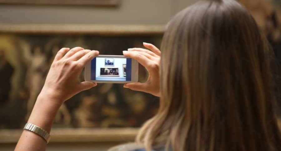Mujer toma foto en museo.