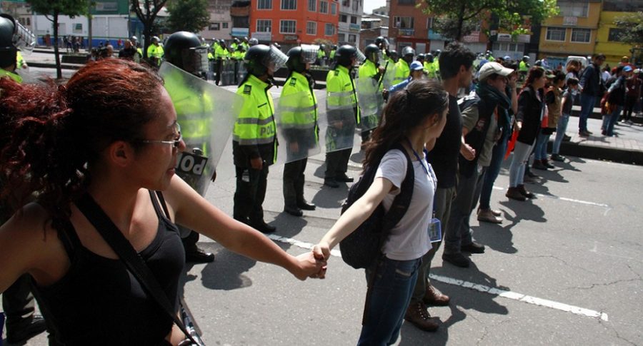 Estudiantes forman una cadena para proteger a policías