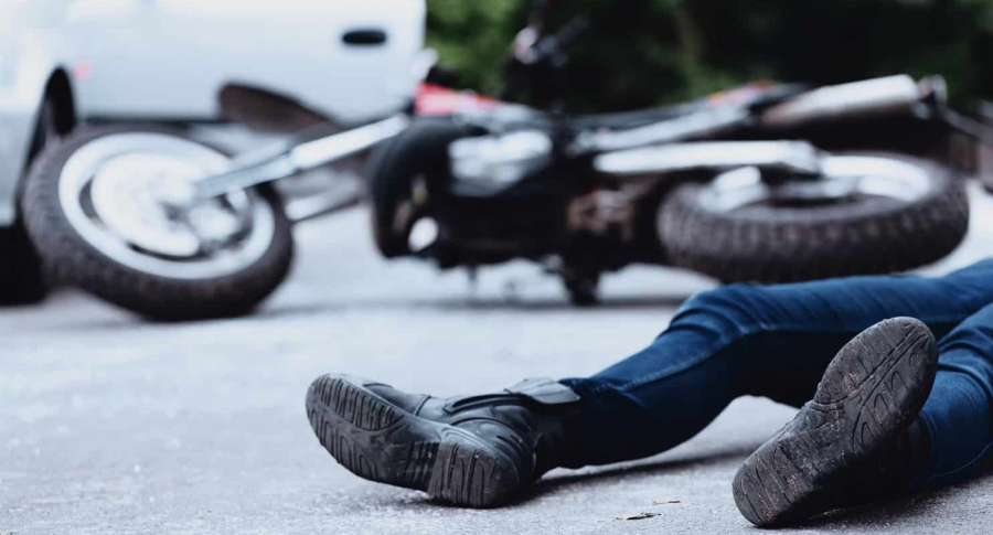 Hombre caído junto a una motocicleta y una camioneta