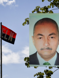 José Aldemar Rojas Rodríguez y una bandera del Eln