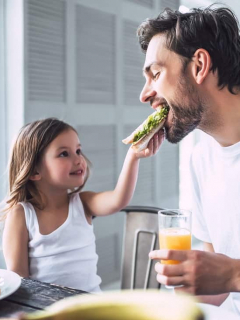 Niña dándole de comer a su papá