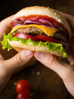 Hombre sostiene hamburguesa.
