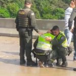 Policías abrazados y llorando porque mujer se lanzó desde puente con su hijo