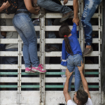 Venezolanos trepan a un camión en la vía Cucuta - Pamplona