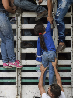 Venezolanos trepan a un camión en la vía Cucuta - Pamplona