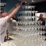 Barman sirve champaña en torre de copas.