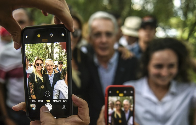 Álvaro Uribe siendo fotografiado con celulares