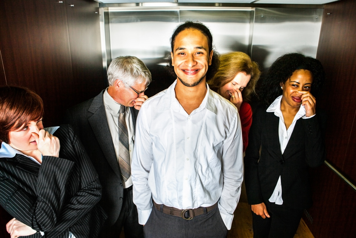 Hombre sonríe después de echarse un pedo en ascensor