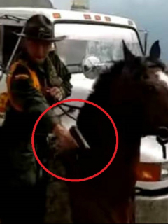 Policía apuntando con su arma