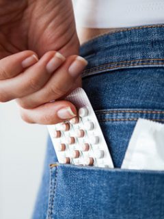 Mujer guardando anticonceptivos en un bolsillo