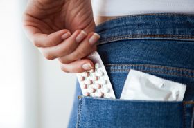 Mujer guardando anticonceptivos en un bolsillo