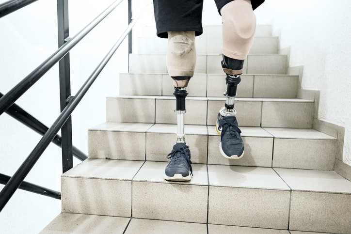 Hombre con piernas protésicas bajando las escaleras