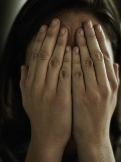 Mujer tapándose el rostro