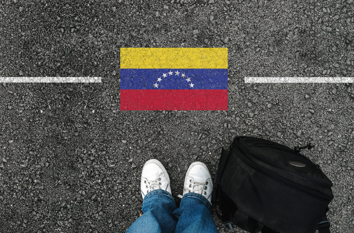 Hombre en tenis y la bandera de Venezuela