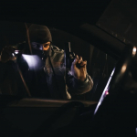Hombre armado observando un carro.