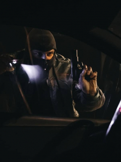 Hombre armado observando un carro.