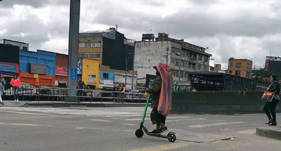 Habitante de calle conduciendo patineta eléctrica.