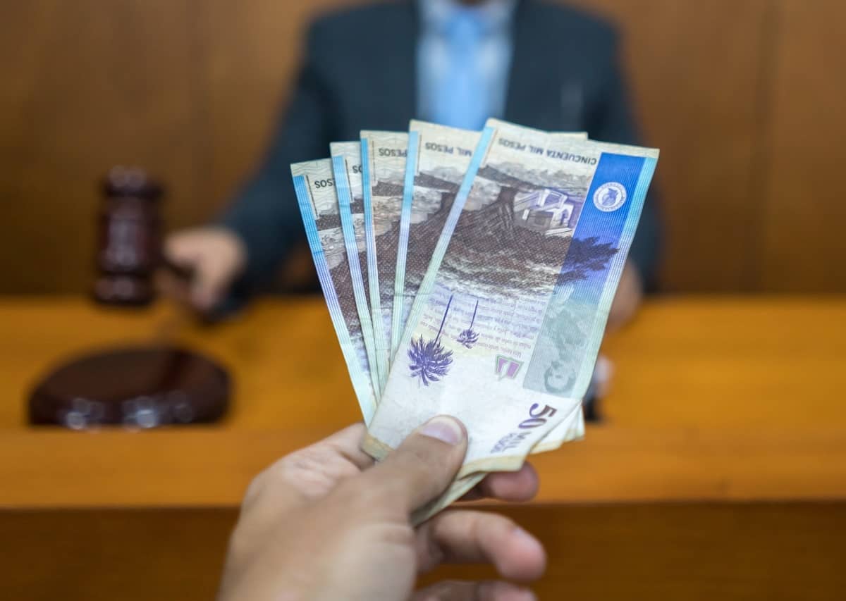 Persona entregando dinero a juez.