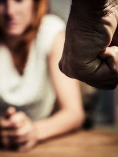 Hombre empuñando su mano frente a una mujer. Maltrato a la mujer.