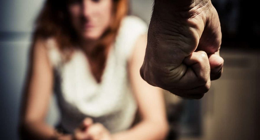 Hombre empuñando su mano frente a una mujer. Maltrato a la mujer.
