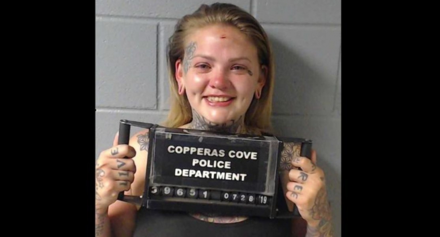 Mujer sonríe en foto de arresto.