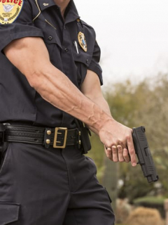 Policía sostiendo una pistola.