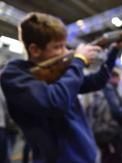 Niño sostiene escopeta armas