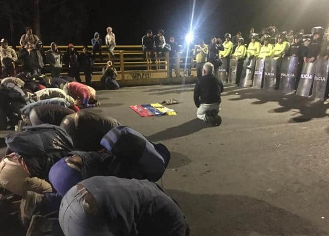 Venezolanos se arrodillan frente a policías ecuatorianos