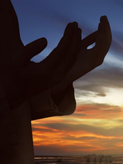 Manos sobrepuestas a atardecer