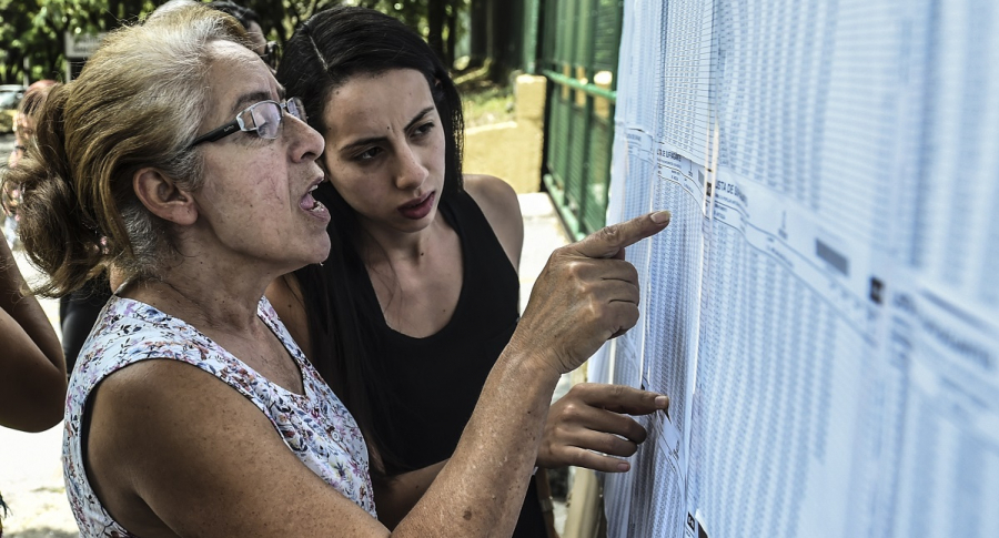 Dos mujeres consultando listas de cédulas