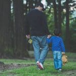 Hombre tomando de la mano a niño