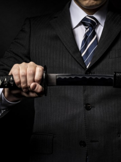 Hombre en traje sostiene espada/sable