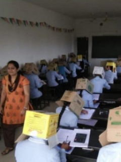 Estudiante usando cajas en la cabeza.