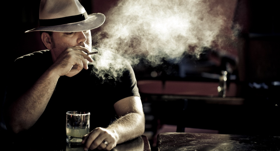 Hombre fumando y bebiendo