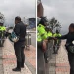 Motociclista orando con policías antes durante el paro nacional