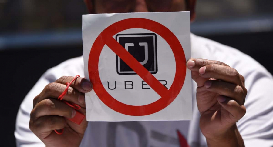 Hombre sostiene cartel de rechazo a Uber