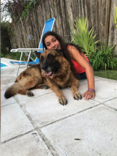 Joven posa con un perro.