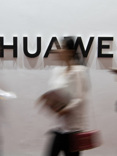 Personas frente al logo de Huawei